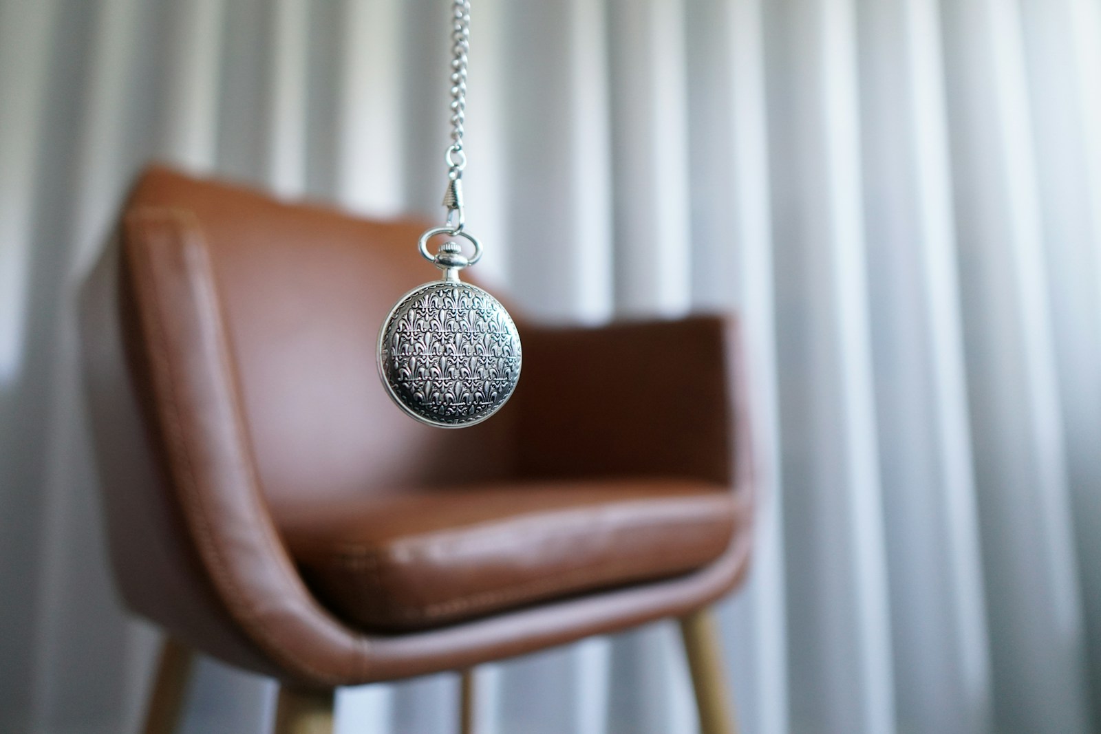 Photo by MK Hamilton silver round pendant on brown wooden chair